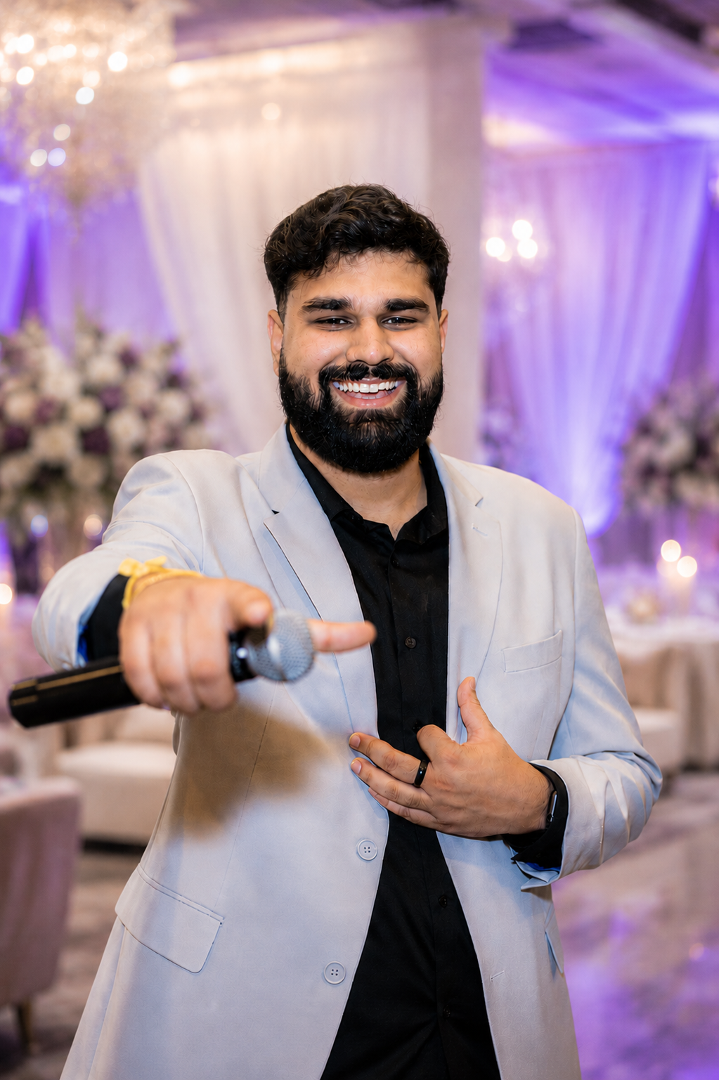 MC Abhinay smiling with a microphone
